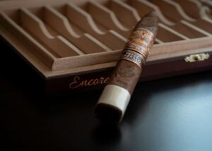 A cigar resting on top of an aging humidor box
